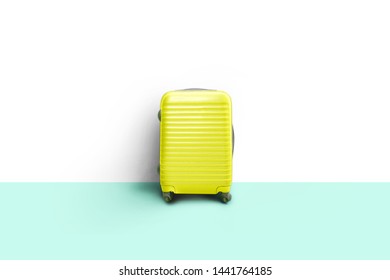Lime green suitcase standing next to the white wall. Concept of tourism and traveling - Shutterstock ID 1441764185