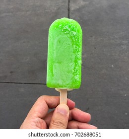 Lime or lemon ice-cream or popsicle in hand 
