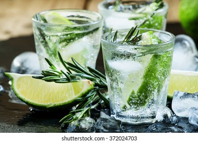 Lime Lemonade with rosemary and ice, dark toned image, selective focus