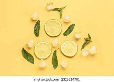Lime slices with ice cubes and mint on orange background