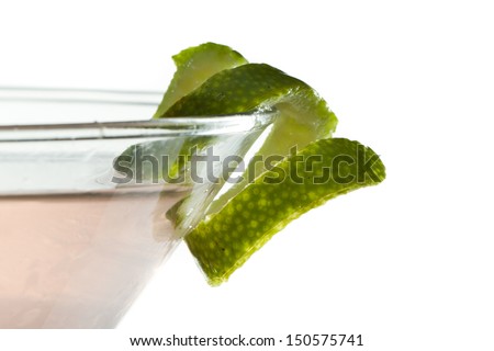 lime twist on the rim of a martini glass used as a garnish isolated on a white background