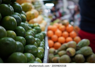 Limes Stacked On Shelf In Grocery Store With Other Fruits In Background