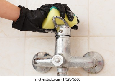 Limescale On Bathroom Mixer Faucet. Hands In Disposable Rubber (latex Or Vinyl) Gloves Cleaning Hard Water Chalky Deposits And Stains On Sink Or Bath Tap. Dirty Plumbing Covered With Lime Scale 