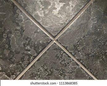 Limescale or soap scum on black tile in the bathroom