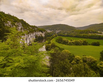 Limestone cliffs in Causses du Quercy, draped with verdant foliage, creating a serene and picturesque scene, showcasing nature's beauty and geological splendor.