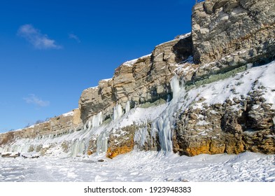 Limestone cliffs in Paldiski on the shores of the Baltic Sea with icicles in winter. clear sunshine and blue sky. Paldiski, Estonia