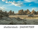 Limestone prehistoric chimneys mineral rock formation and offroad 4x4 vehicle, salt lake Abbe, Dikhil region, Djibouti