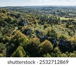 Limestone rock surrounded by autumn forest.Aerial drone view of Rzedkowice limstone Rocks.Group of rocks in Rzedkowice town. Jurassic limstone rocks in Poland. Jura Krakowsko - Czestochowska, Poland.