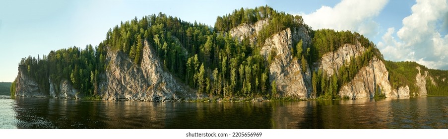 Limestone rocks overgrown with coniferous forest on the bank of a mountain lek river in summer in sunny weather. High resolution photo. Vishera river, Pisany stone, Perm region, Russia - Shutterstock ID 2205656969