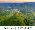 The limestone rocks and a village at the bottom in Wuzhishan Scenic Area, Cuiping Village, Grape Town, Guilin, Guangxi China, drone shot