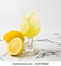 Limoncello Cocktail With Lemon In A Beautiful Glass On A Light Background And A Marble Table