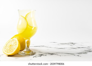 Limoncello Cocktail With Lemon In A Beautiful Glass On A Light Background And A Marble Table