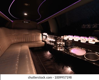 Limousine Interior By Night With Bar, Champagne Crystal Bottles And Pink Light.