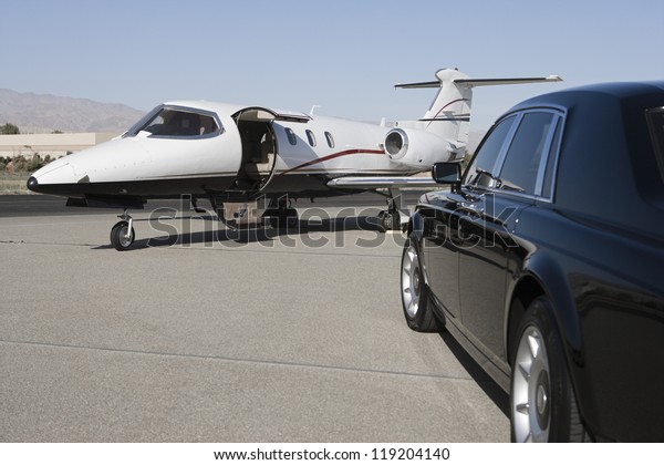 Limousine and private\
jet on landing strip
