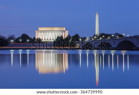 Lincoln Memorial and the Washington monument, DC landmarks, illuminated in the blue hour and reflecting in the water of the Potomac River.