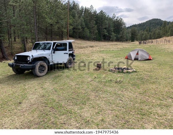 Lincoln National Forest, NM USA April\
17, 2020: Campsite with a Jeep Wrangler, tent, fire pit, and chairs\
located in the Lincoln National\
Forest.