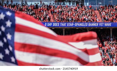 Lincoln, Nebraska, USA - April 9, 2022: The American Flag Flies During The National Anthem Before The Annual Red-White Spring Game At Memorial Stadium In Lincoln.