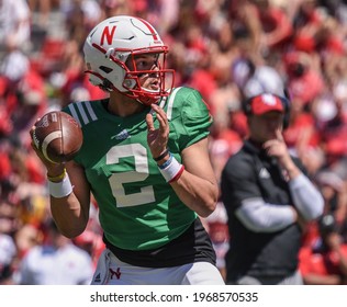Lincoln, Nebraska, USA - May 1, 2021: Nebraska football quarterback Adrian Martinez, with coach Scott Frost in the distance, during the annual Red-White Spring Game at Memorial Stadium in Lincoln.