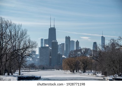 Lincoln Park lagoon covered in ice with the Chicago skyline in the background in winter