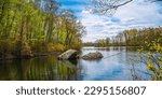 Lincoln Woods State Park and Olney Pond spring landscape with glacial rocks in the water and new sprouts on the trees near Providence, Rhodes Island, USA