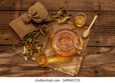 Linden tea. Dry fragrant flowers. Sunny morning breakfast. Hot drink to strengthen the immune system, alternative medicine. Vintage wooden table - Shutterstock ID 1699691725