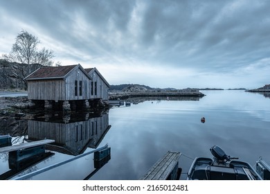 Lindesnes, Norway - April 16 2022: Old Boat Houses By A Small Barbour At Night.