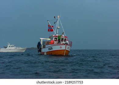 Lindesnes, Norway - August 07 2021: A Traditional Small Wooden Fishing Trawler With A Large Norwegian Flag.