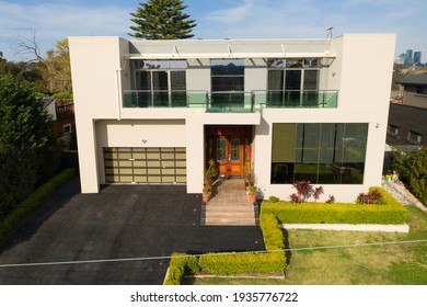 Lindfield, Sydney, Australia - Sept 17 2020: Aerial Shot Of The Front Of A Luxury Suburban Home With Two Levels, Double Garage, Driveway, Glass Windows And Garden