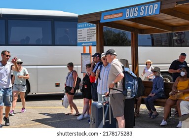 Lindos, Rhodes, Greece - May 2022: People Waiting For A Public Service Bus At The Town's Bus Stop