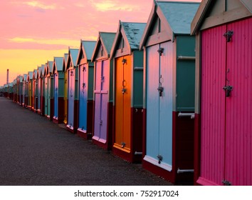 a line of 30 beach huts with a diminishing perspective, the nearer beachhuts are big, lamp post and promenade, brighton seafront - Powered by Shutterstock
