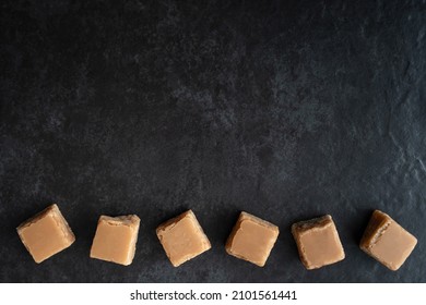 Line of Butterscotch Fudge from Above on a Dark Background with Copy Space