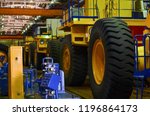 Line, conveyor for the production of large yellow trucks, mining trucks. Shop factory. Huge tires with rims