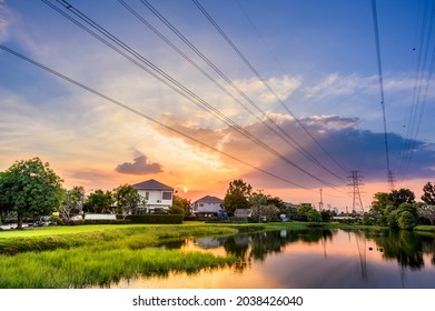 Line of high voltage power with electricity transmission close to residential buildings. Power transmission tower in city with urban area - Shutterstock ID 2038426040