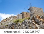 Line up of historic windmills on a ridge at Lasithi Plateau on the Greek island of Crete.