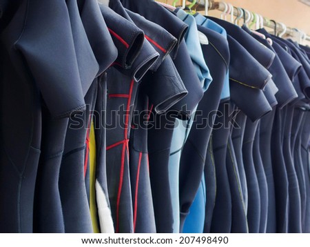 Line of multiple hanging wetsuits at scuba diving center. 商業照片 © 