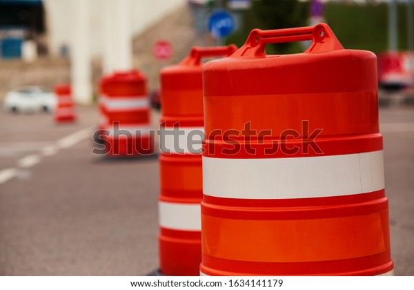 line of orange traffic\
barrier barrels 