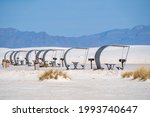 Line up of retro style picnic rest area tables and structures inside of White Sands National Park in New Mexico