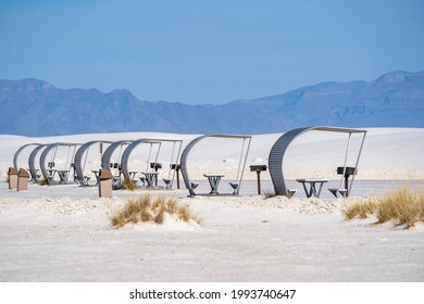 Line up of retro style picnic rest area tables and structures inside of White Sands National Park in New Mexico