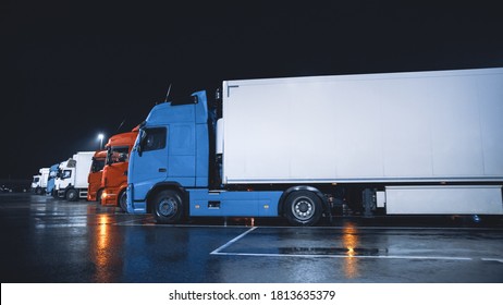 Line of Semi-Trucks with Cargo Trailer Drives Standing on the Overnight Parking Place. Drivers Resting at Night on the Overnight Parking Lot.