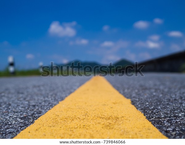 The line of\
yellow road leads to the\
mountain.