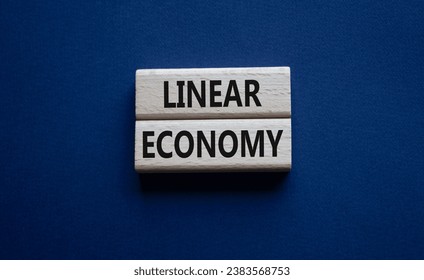 Linear Economy symbol. Concept words Linear Economy on wooden blocks. Beautiful deep blue background. Business and Linear Economy concept. Copy space.