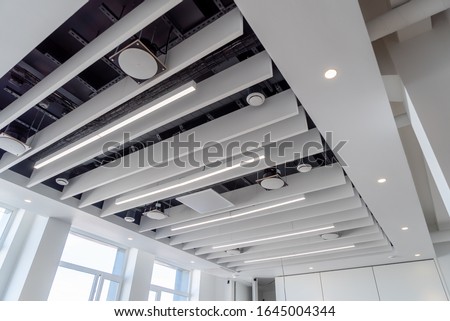 linear LED lights and sound absorbing ponies hang on a plasterboard ceiling with integrated spotlights