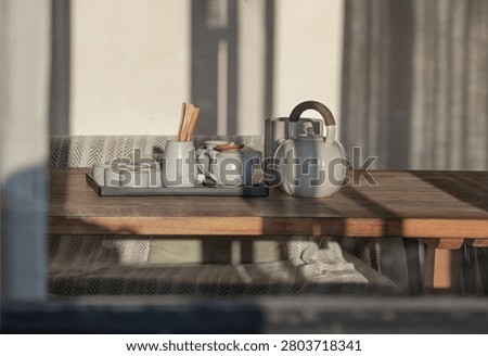 Linear window-pane shadows slice cleanly across the tea service and the soft cream wall behind it. Soft afternoon light illuminates a ceramic teapot, small matching cups on a tray, and a chevron-patterned textile backdrop.