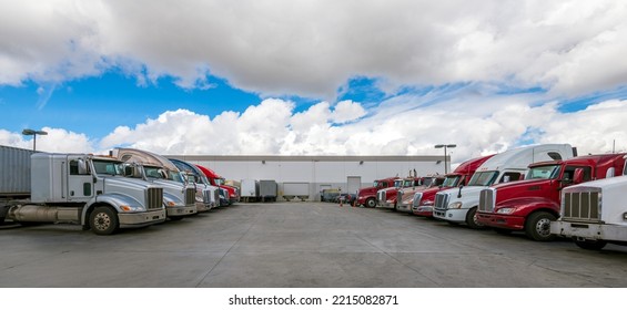 Lined Up Semi Trucks On A Parking Lot At Logistics Warehouse.