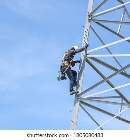 Lineman Climbing On Transmission Line Tower