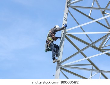 Lineman Climbing On Transmission Line Tower