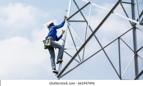 Lineman Climbing On Transmission Line Tower 