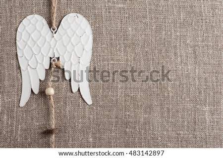 Linen background with christmas decoration. Angel wings toy. Wedding, xmas rough texture flat lay