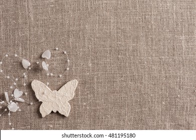 Linen background with wedding decoration. White butterfly. Wedding, xmas rough texture flat lay
