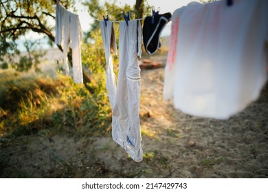 Linen Clothes Are Dried On A Rope Among Trees, Sand And Beach And Clothesline